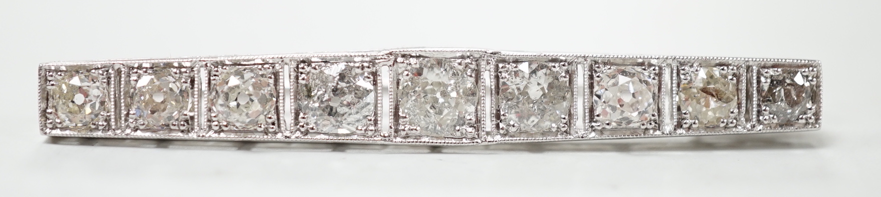 A 1920's/1930's white metal and graduated nine stone diamond set bar brooch, 48mm, gross weight 4.6 grams.